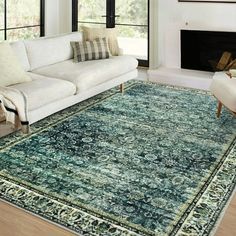 a living room filled with furniture and a large rug on top of a hard wood floor