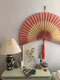 a table with a lamp, fan and pictures on it