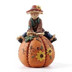 a figurine sitting on top of a pumpkin