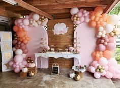 a baby shower is decorated with balloons and gold accents, such as an arch for the entrance