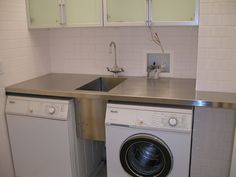 a washer and dryer in a small kitchen with wooden counter tops on the island