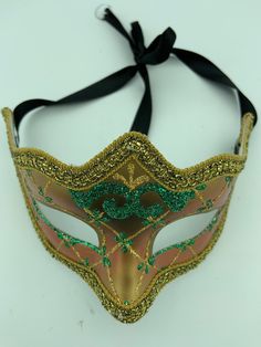 "This is a very nice original handmade and hand painted Venezia masquerade face mask made in Italy. The design on the shiny gold and orange face mask features turquoise blue and multi-color glitter with a border of gold lace and gold rope around the edges. It comes with a black ribbon tie and is stamped on the back \"Original Hand Painted Made in Italy Venezia\". The mask measures approximately 6 5/8\" long and 3 3/4\" wide and is in very good preowned condition with light wear on the back of th Adjustable Masquerade Mask For Mardi Gras, Venetian Mask For Mardi Gras Costume, Venetian Masks For Carnival Costume, Venetian Costume Masks For Carnival, Venetian Masks For Mardi Gras Costume Party, Venetian Mask For Carnival Costume Party, Venetian Mask For Costume Party And Carnival, Venetian Masks For Mardi Gras, Venetian Masks For Mardi Gras Carnival