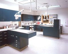 a large kitchen with blue cabinets and white counter tops