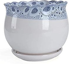 a white bowl sitting on top of a metal stand with blue and white designs in it