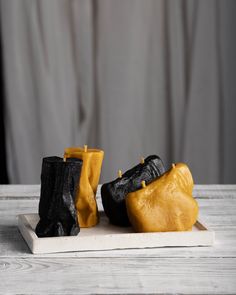 two black and yellow shoes sitting on top of a wooden table next to each other