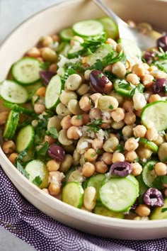 a bowl filled with cucumber, black eyed peas and other veggies