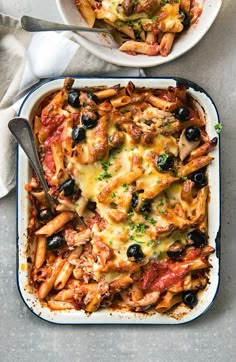 two bowls filled with pasta and black olives