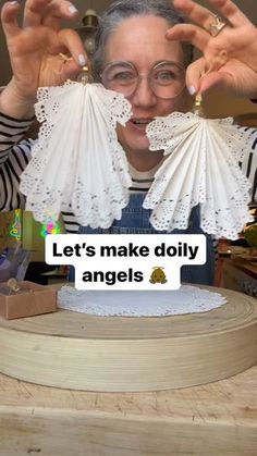 a woman holding up two paper fans with the words let's make diy angels