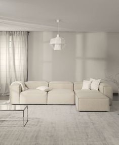 a large white couch sitting in a living room next to a window