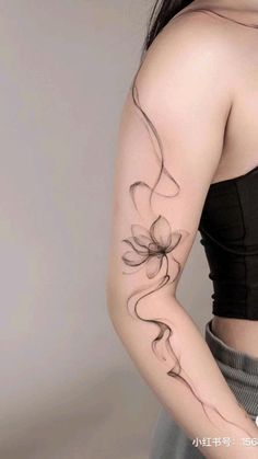 a woman with a flower tattoo on her left arm and right arm behind her back