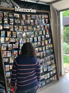 a woman standing in front of a wall covered with pictures