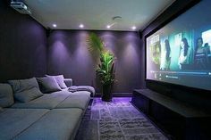 a living room with couches and a flat screen tv on the wall in front of it