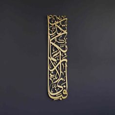 an intricately designed metal object on a black background with gold lettering and arabic writing