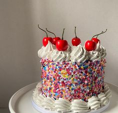 a cake with sprinkles and cherries on top