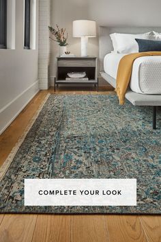 a bedroom with wood floors and a large rug on the floor that says, complete your look