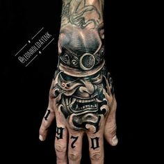 a man's hand with tattoos on it