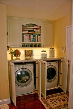 a washer and dryer in a small room with books on the shelves above