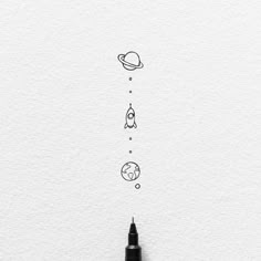 an ink pen drawing the planets and stars on white paper with space in the background