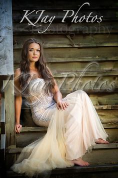 a beautiful young woman sitting on top of a wooden bench next to a wall with the words kay photos