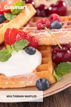 the waffles are topped with berries and whipped cream