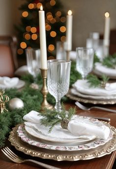 a christmas table setting with candles and plates