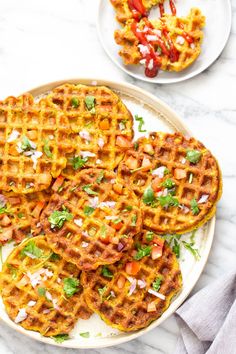 several waffles on a white plate topped with chopped red peppers and cilantro