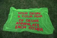 a green plastic bag with red writing on it that says your distance & your fear of despair annihitate each other