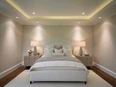 a large white bed sitting in a bedroom next to two lamps on either side of it