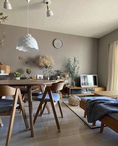 a living room filled with furniture and a wooden table in front of a large window