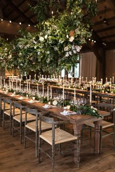 a long table with candles and greenery is set up for a formal function at the barn