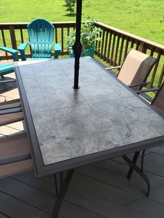 a table with an umbrella sitting on top of it next to chairs and a lawn