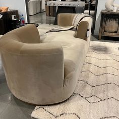 a living room filled with furniture on top of a carpeted floor next to a white rug