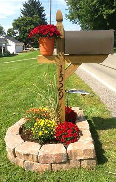 a mailbox is decorated with flowers in a flower bed