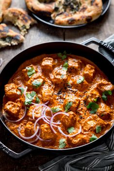 a skillet filled with chicken tikka and onions