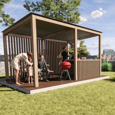 a group of people sitting at a table in a small wooden structure on the grass