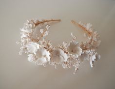 The Freya crown is a floral beauty featuring white clay flowers and glass beads on a fine gold band. A soft, whimsical piece to elevate your bridal look. All pieces are designed and handmade in England, using high quality beads and embellishments, tarnish free jewellery wire and a comfortable headband base ideal for wearing over long periods of time.  LEAD TIME Made to order in 3-4 weeks, plus delivery time.  UK Delivery: 2-5 working days (Royal Mail Tracked) International Delivery: 5-10 working days (International Tracked & Signed) RUSHED ORDERS Please get in touch if you need your piece sooner. This is sometimes possible with a rushed order fee but entirely depends on the design and time frame it is needed within.  CUSTOM DESIGNS Designs can be customised to suit your hairstyle or weddin Handmade Wedding Crown With Structured Shape, Cream Flower Headpieces For Weddings, Wedding Headpiece With Handmade Flowers And Structured Crown, Pink Pearl Flower Crown, Cream Flower-shaped Headband With Handmade Flowers, Black Hair Bows, Bridal Floral Crown, Comfortable Headbands, Occasion Dresses Wedding