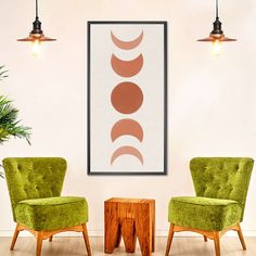 two green chairs sitting next to each other in front of a wall with three circles on it