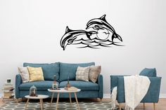 a living room with blue couches and a dolphin wall decal on the wall