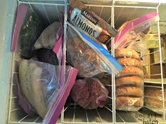 an open refrigerator filled with lots of food and plastic bags on top of the shelves