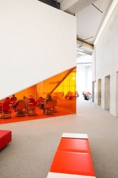 an office lobby with red and white benches