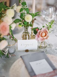 the table is set with flowers and place cards