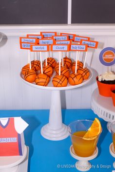 a basketball themed birthday party with cupcakes, orange juice and cake on a plate