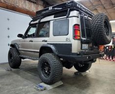 the jeep is parked in the garage with its lifted tires