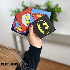 a person holding up some cards with batman and superman logos on them