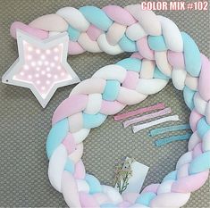 a pink, blue and white braided wreath with a star on it's side