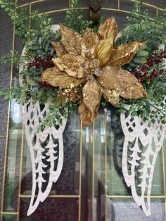 a christmas wreath with gold leaves and red berries