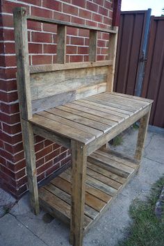 a wooden bench sitting next to a brick wall