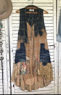 an old dress hanging on a wall with some cowboy hats and other items around it