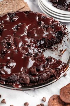 a chocolate cake on a plate next to crackers