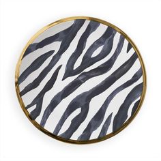 a black and white zebra print plate with gold trim